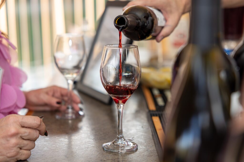 Group of people enjoying a wine-tasting event, holding glasses of wine